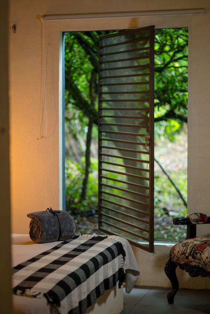 Ventana abierta con vista al bosque desde habitación en eco lodge en Boyacá.