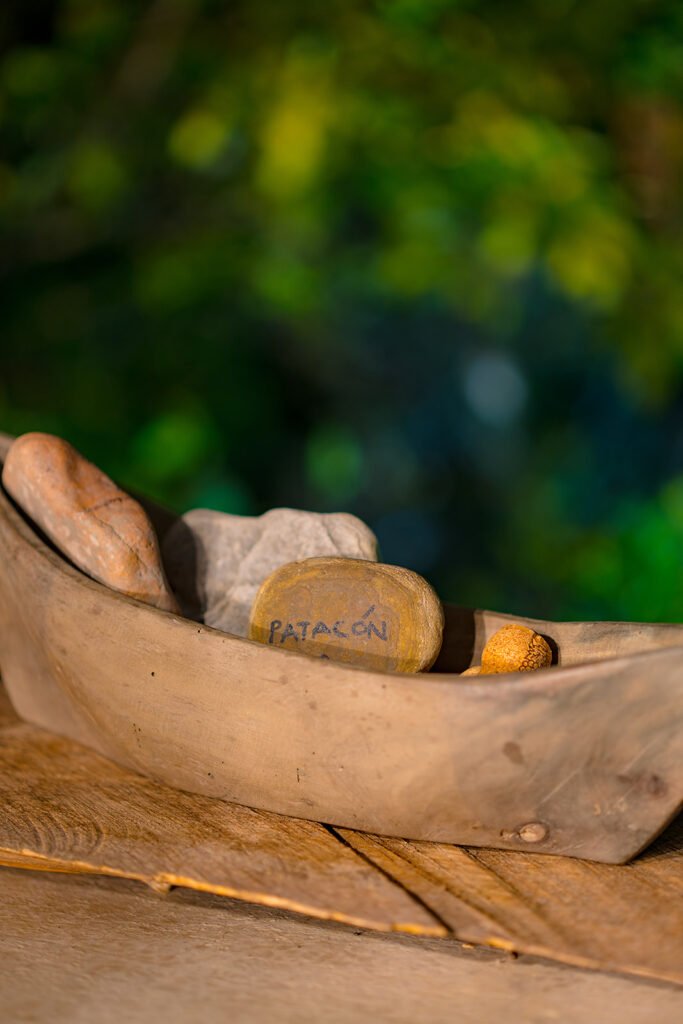 Piedras decorativas con palabras inspiradoras en recipiente rústico de madera en eco lodge Rivabella, Boyacá.