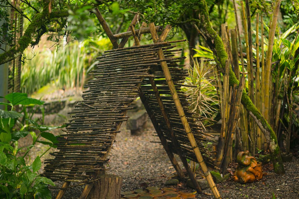 Estructura artesanal en madera rodeada de vegetación nativa en los jardines de Rivabella Eco Lodge, Boyacá.
